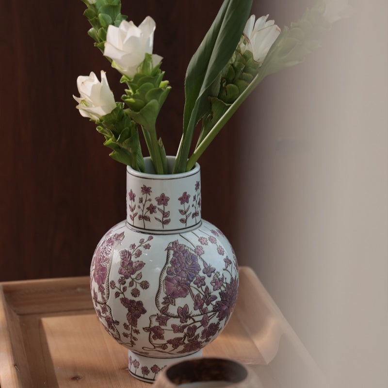 Detailed view of ceramic floral vase with white flowers on wooden tray