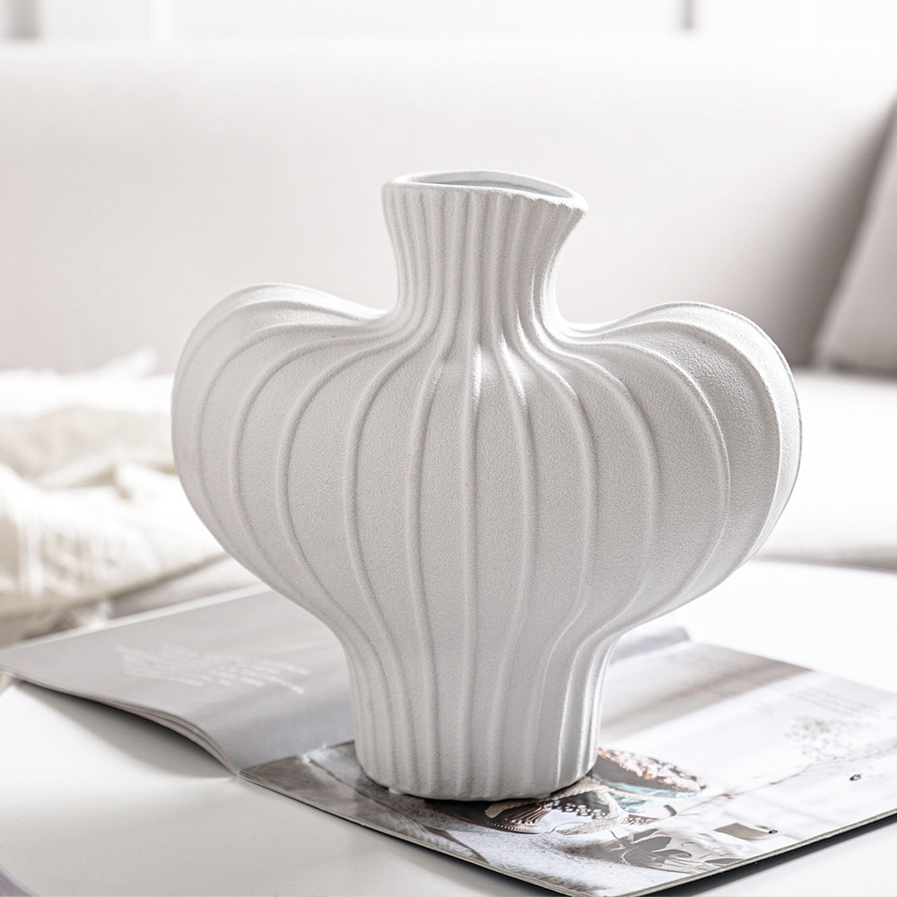 White ceramic fluted vase on magazine close up