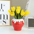 Glazed ceramic strawberry vase with yellow tulips