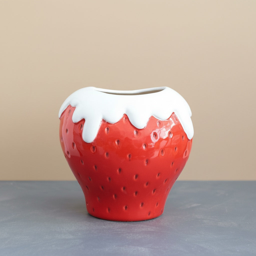Glazed ceramic strawberry vase empty on a table