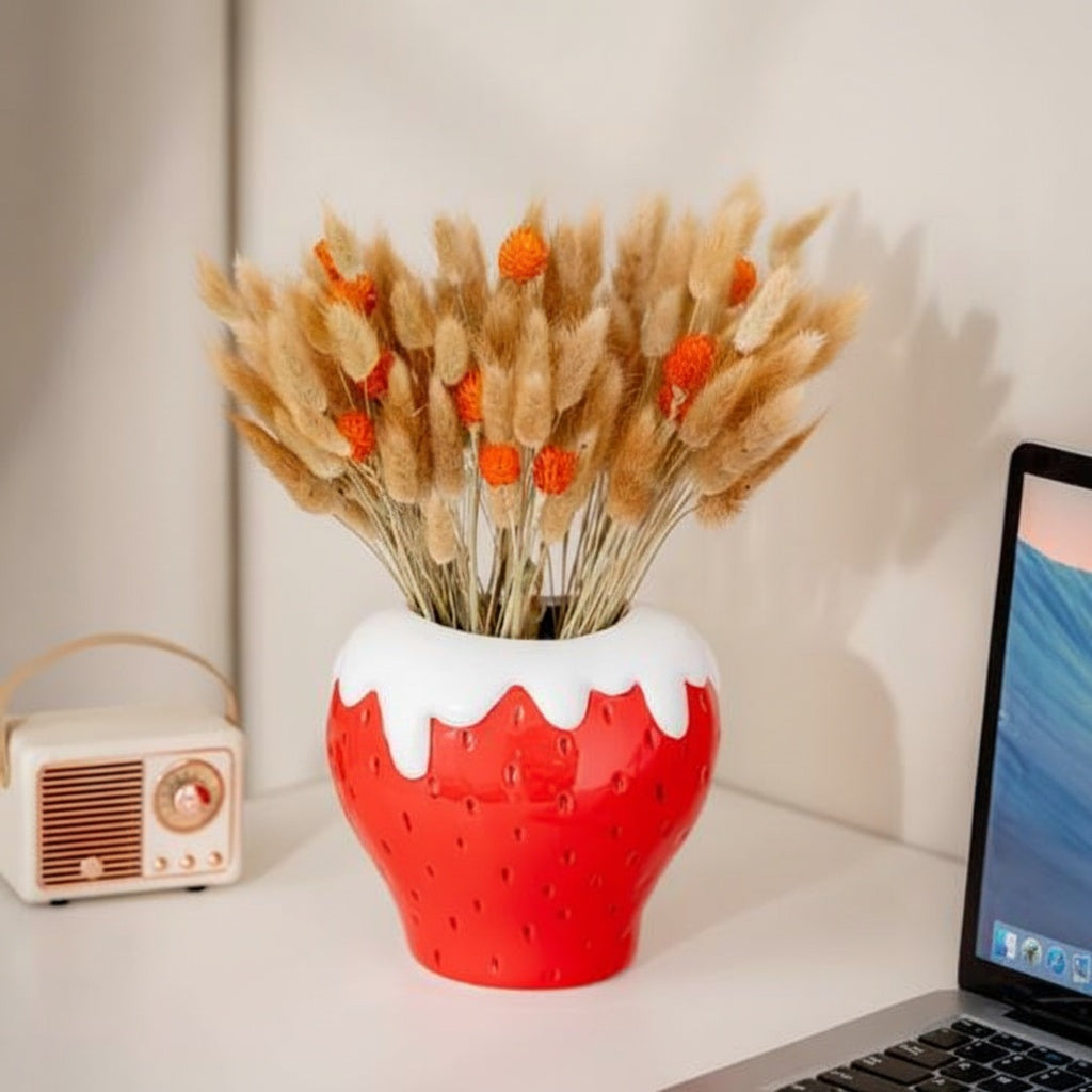 Glazed ceramic strawberry vase with dried grass