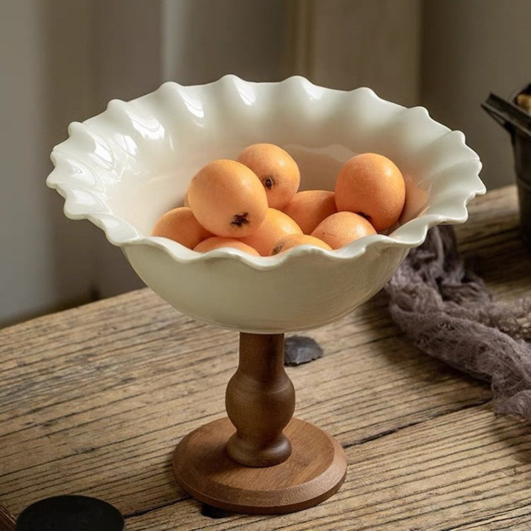 High angle view of ruffled rim ceramic bowl with loquats on rustic table