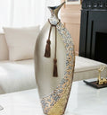 Close up of tall champagne gold vase with silver texture