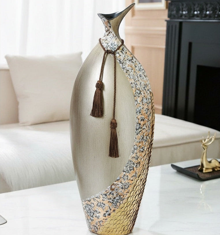 Close up of tall champagne gold vase with silver texture