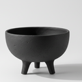 Charcoal black ceramic tripod bowl with a sculptural matte texture and elevated pedestal design for minimalist interiors.