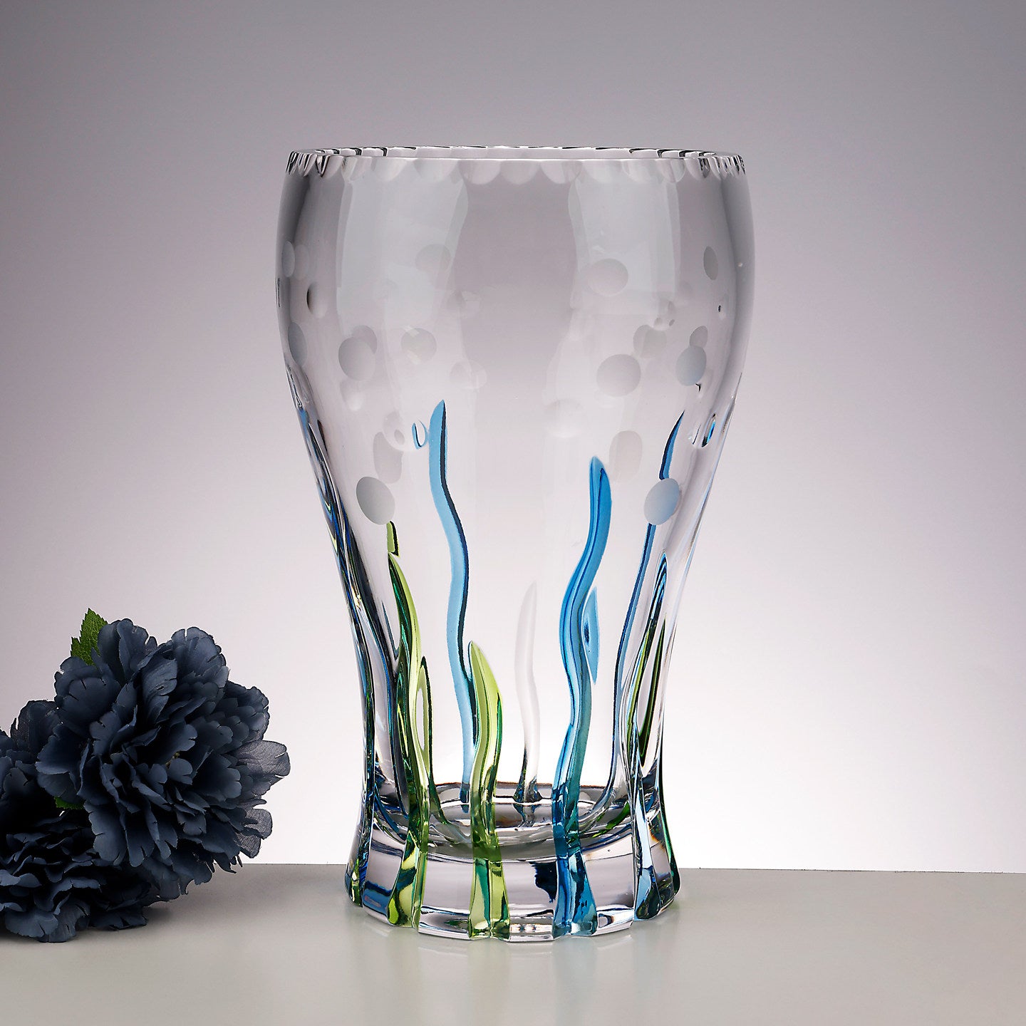 Front view of clear art glass vase with blue and green accents