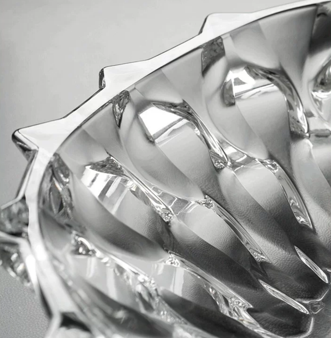 Close-up of clear faceted crystal glass bowl showing detailed cut-glass texture and reflective finish