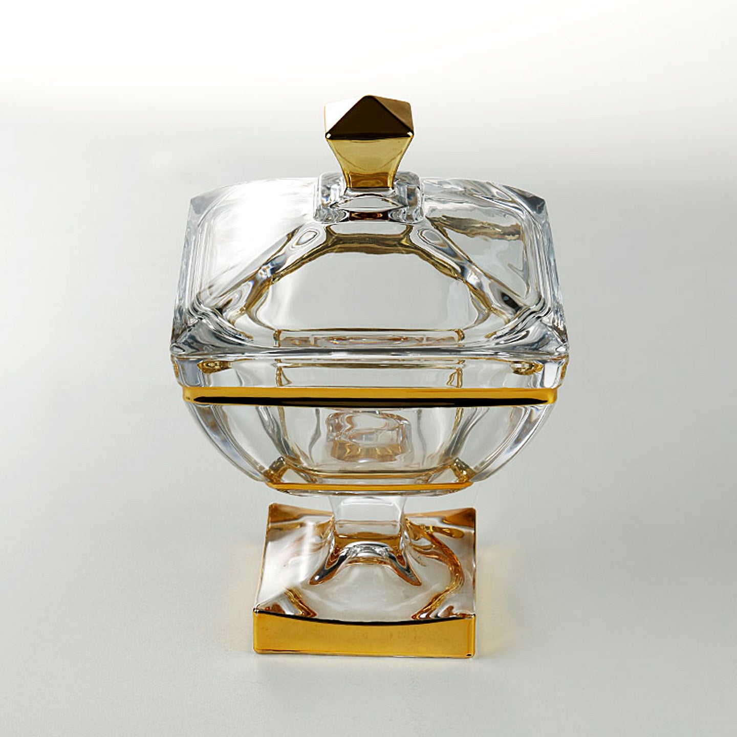 Front view of square glass candy jar with gold accents and lid