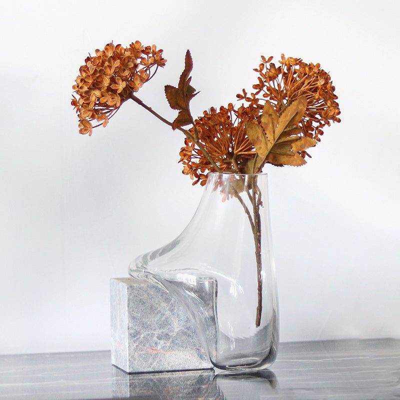 Side view of melted glass vase on marble base