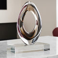 Front view of clear glass oval sculpture on marble surface