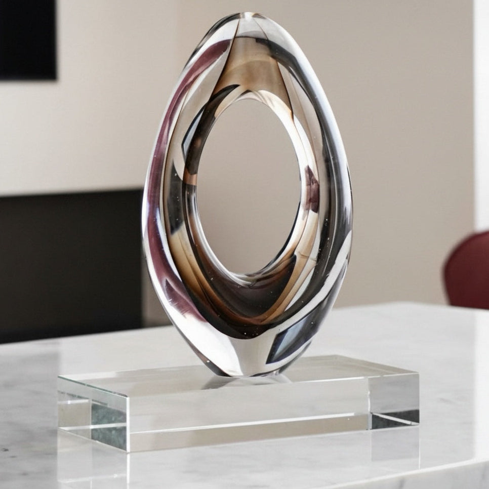 Front view of clear glass oval sculpture on marble surface