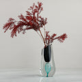 Clear glass sculptural vase with red foliage