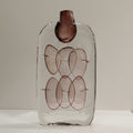 Front view of large tall clear glass vase with internal mauve bubbles