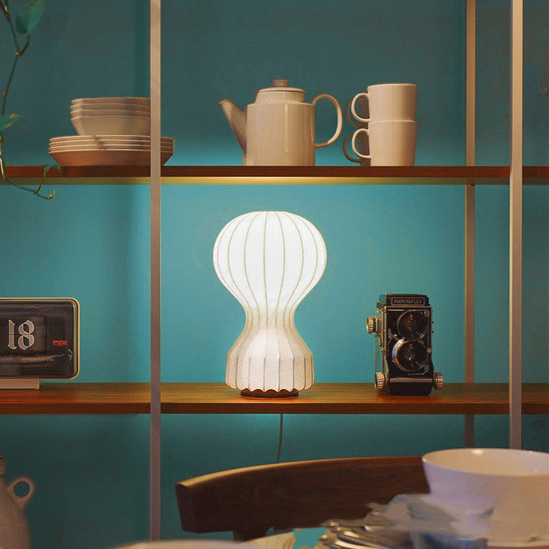 Illuminated cocoon resin table lamp on shelf