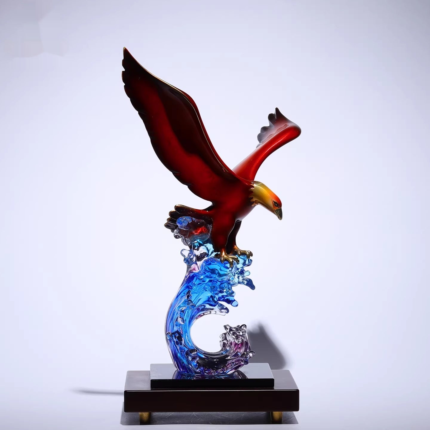 Side profile of polished copper eagle sculpture on blue crystal wave