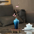 Angled view showing copper branch detail and blue ceramic glaze finish