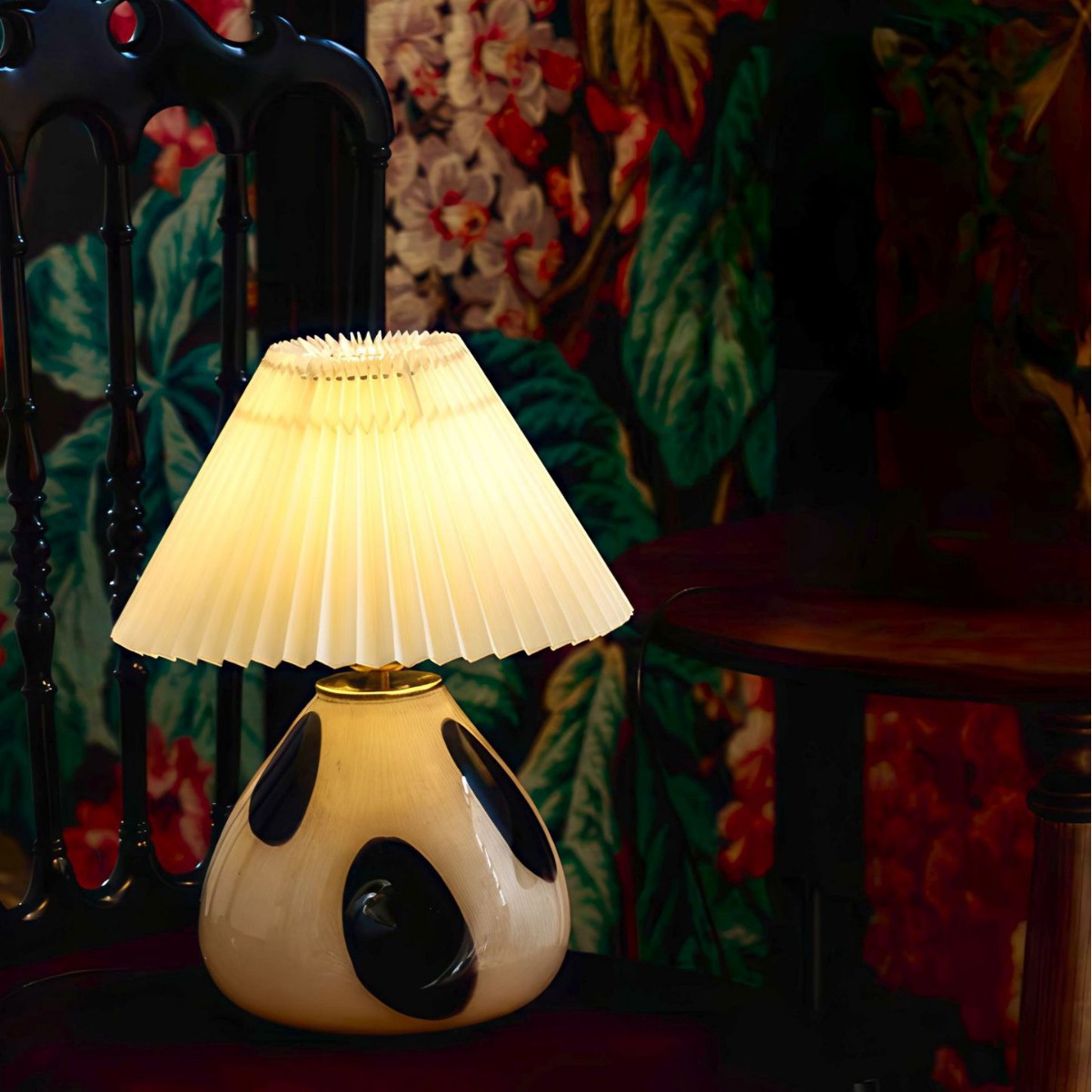 Illuminated ceramic table lamp on chair in eclectic setting