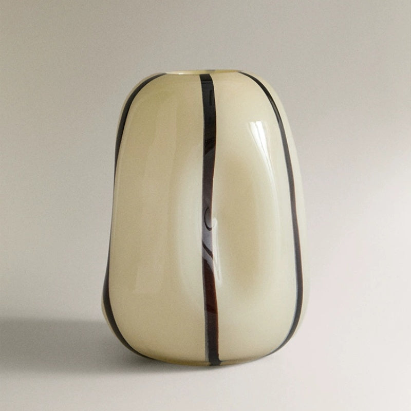 Angled studio view of cream and black art glass vase