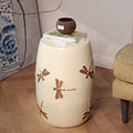 Detail of bronze dragonfly relief on cream ceramic stool