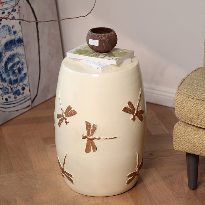 Detail of bronze dragonfly relief on cream ceramic stool