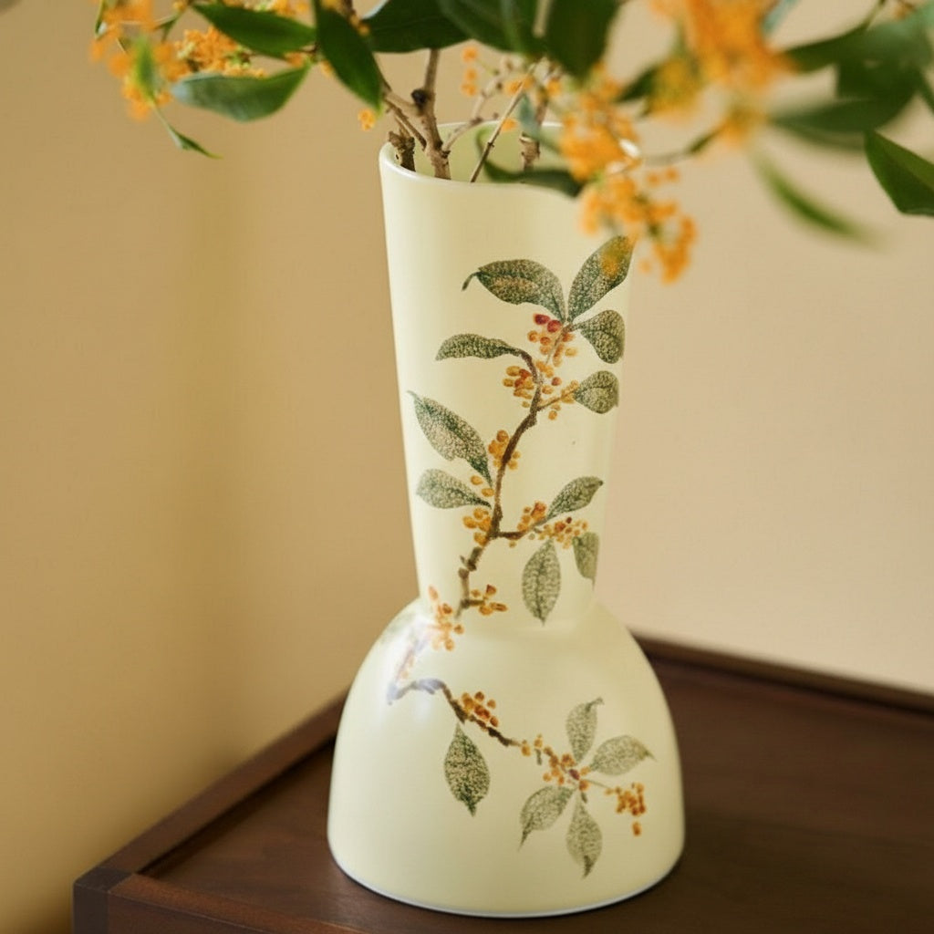 Cream ceramic vase with floral pattern holding branches