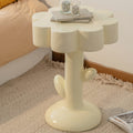 Cream fiberglass flower side table with books and candles