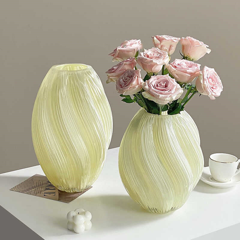 Cream swirled glass oval vases set on table