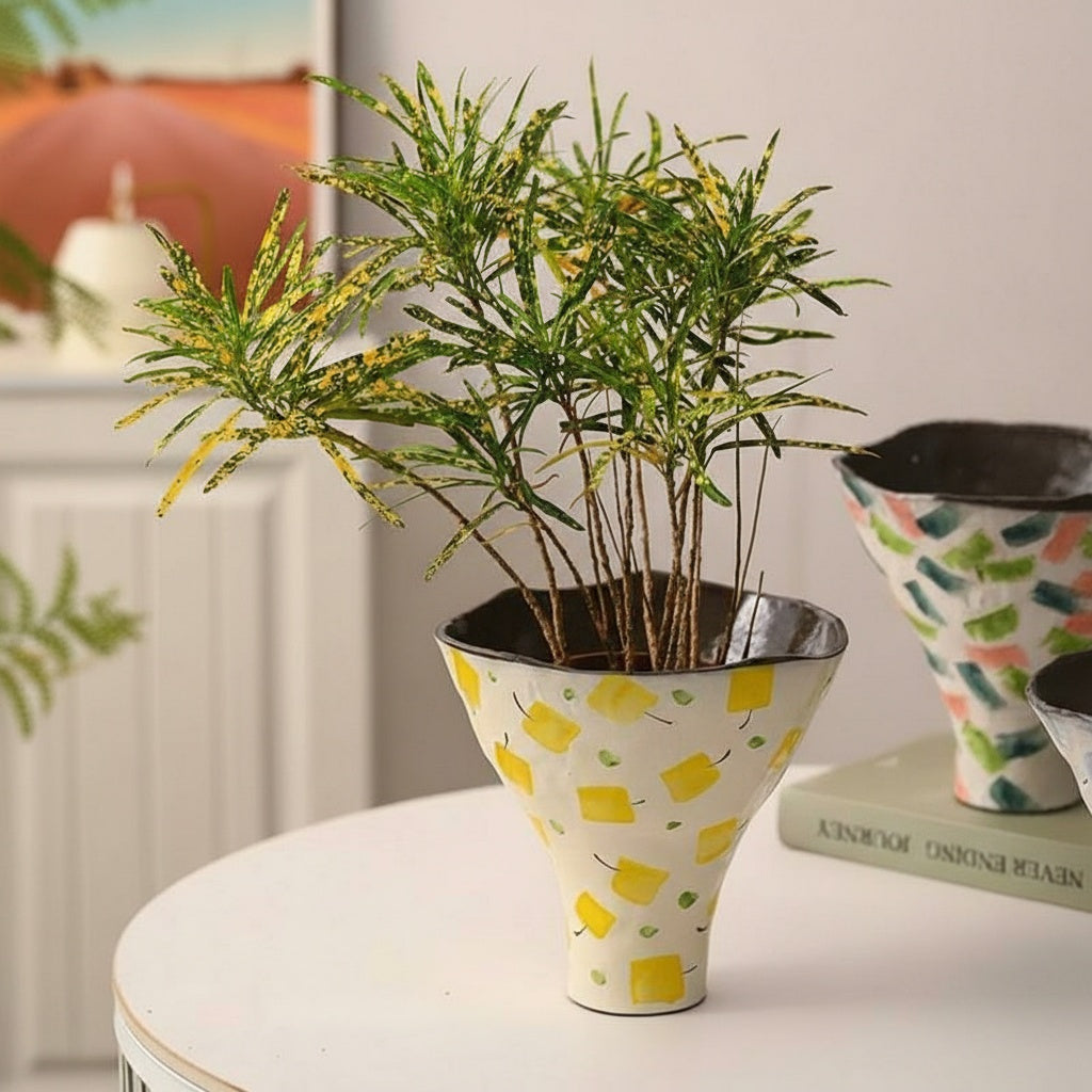Ceramic vase with green plants showing tapered shape and pattern