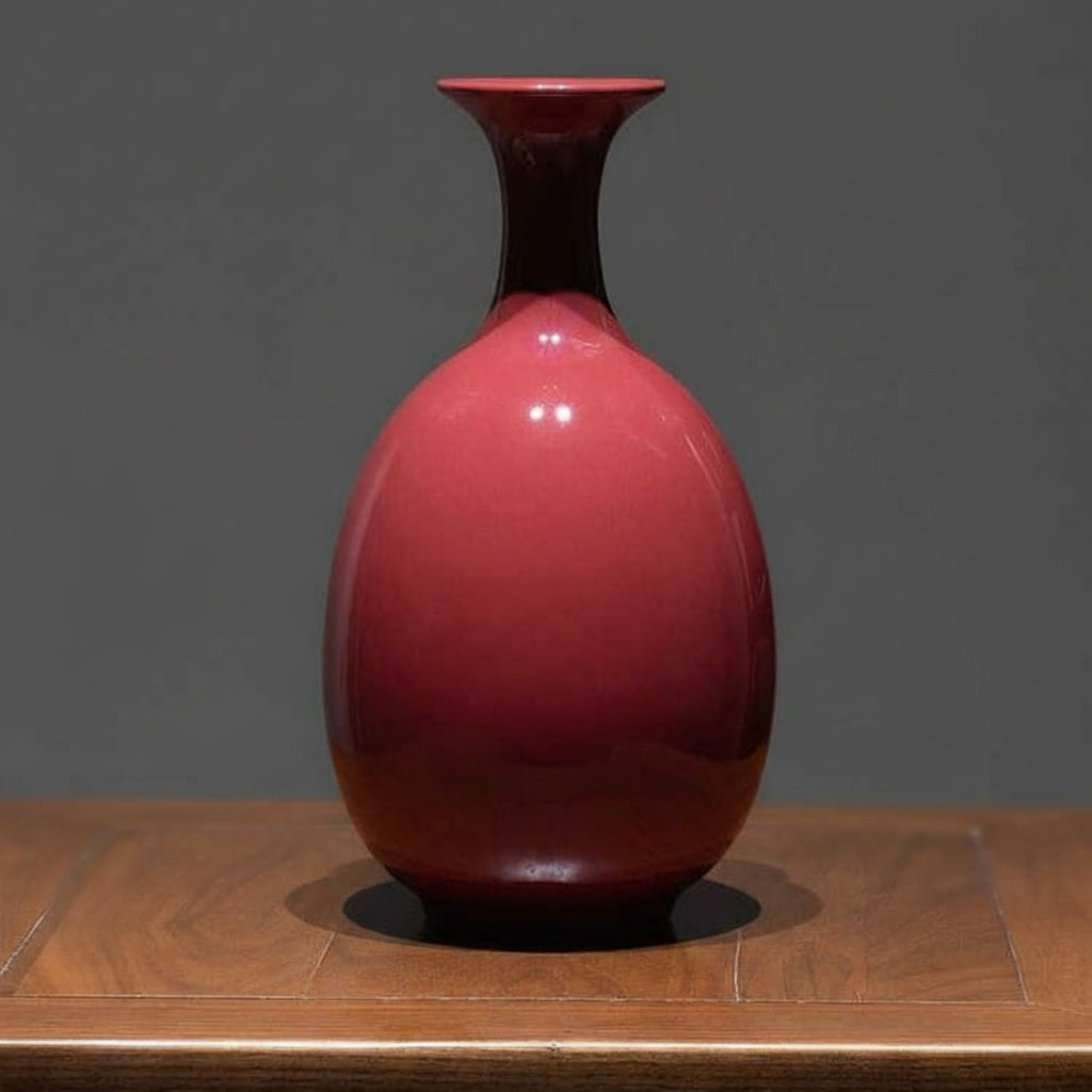 Front view of crimson ceramic bottle vase on wooden table