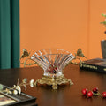 Angled view of crystal fan bowl with brass butterfly handles on table