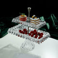 Angled view of 2-tier glass stand with pastries and fruit