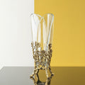 Front view of crystal vase with brass floral base on split background