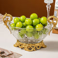 Side view of gold and glass pedestal bowl with fruit