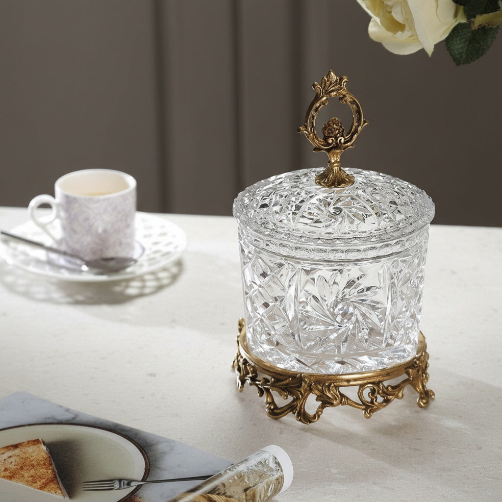 Cut glass and brass lidded jar on table setting with coffee cup