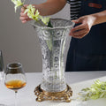 Full view of cut glass vase on gold base with flowers