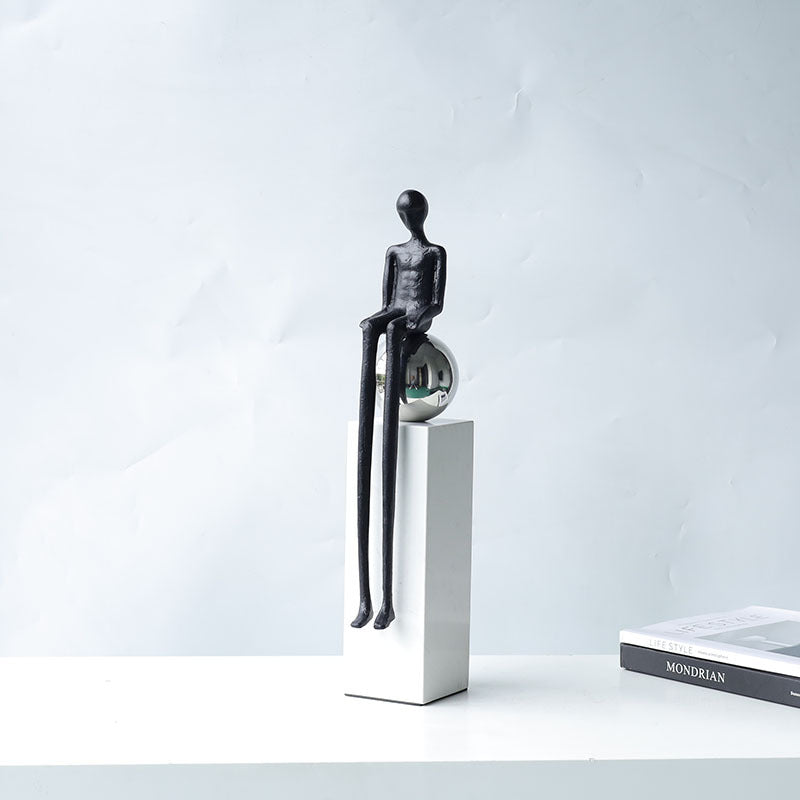 Front view of sitting figure sculpture on white column base