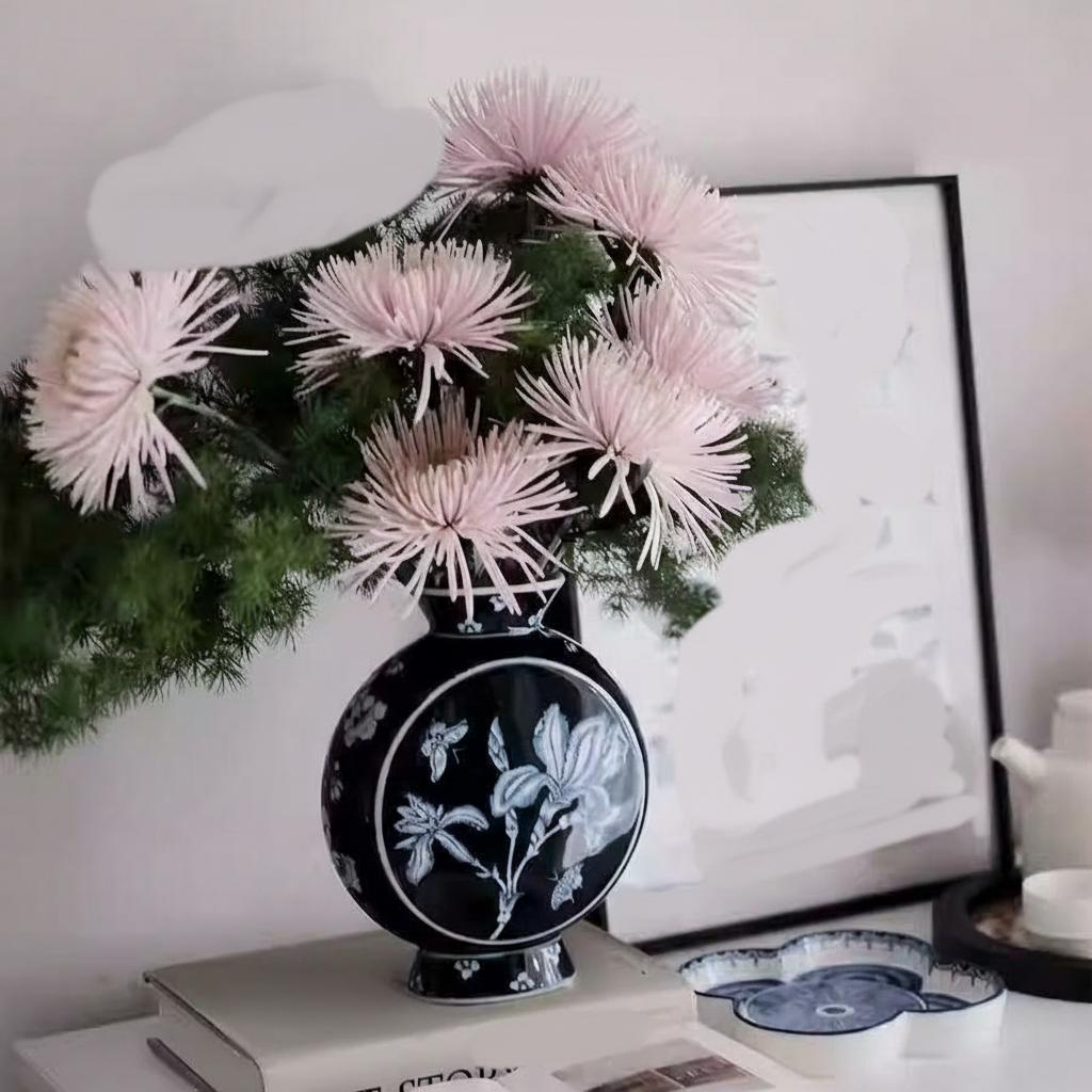 Angled view of ceramic floral vase on books