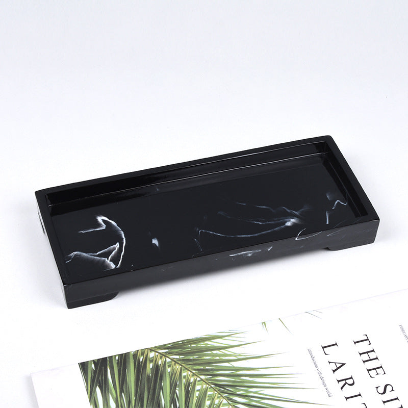 Black and white resin trays styled together with diffuser and book