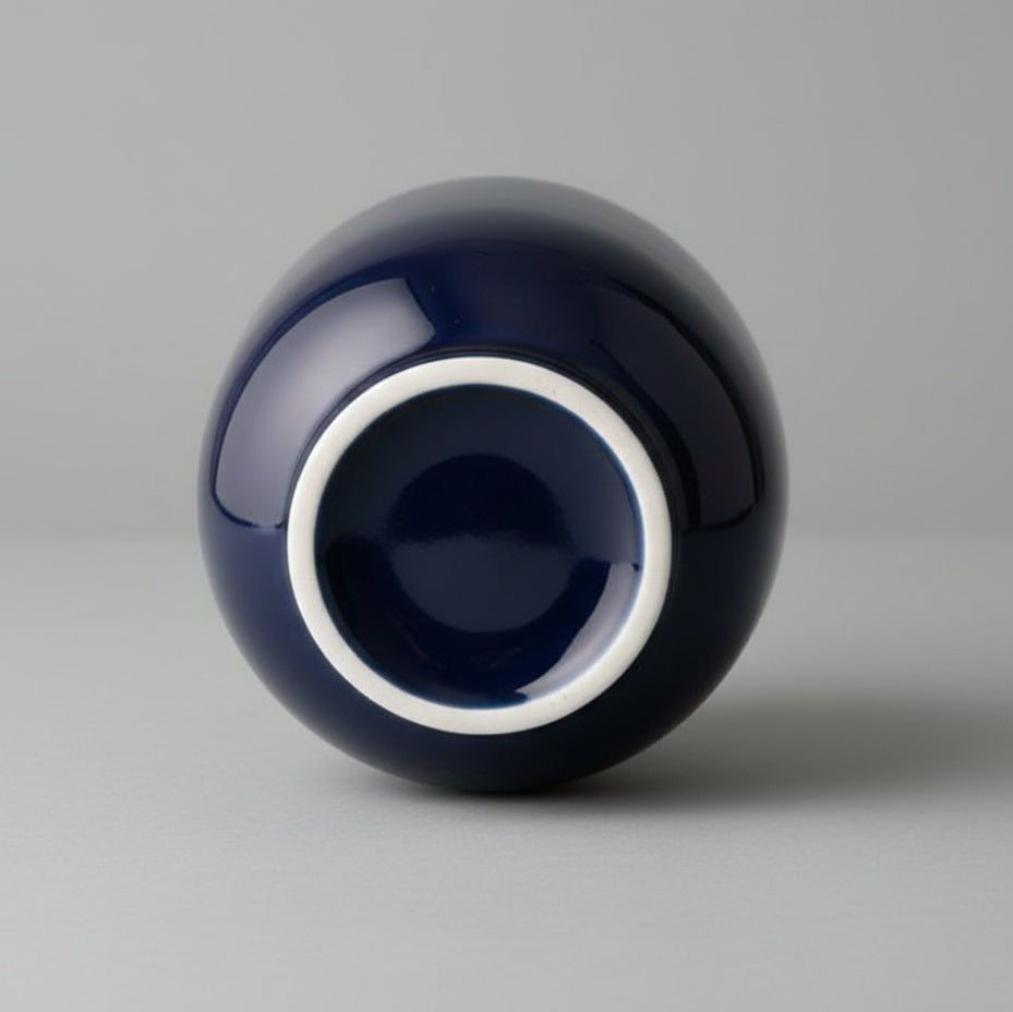 Close up of glossy blue ceramic vase base and white foot ring