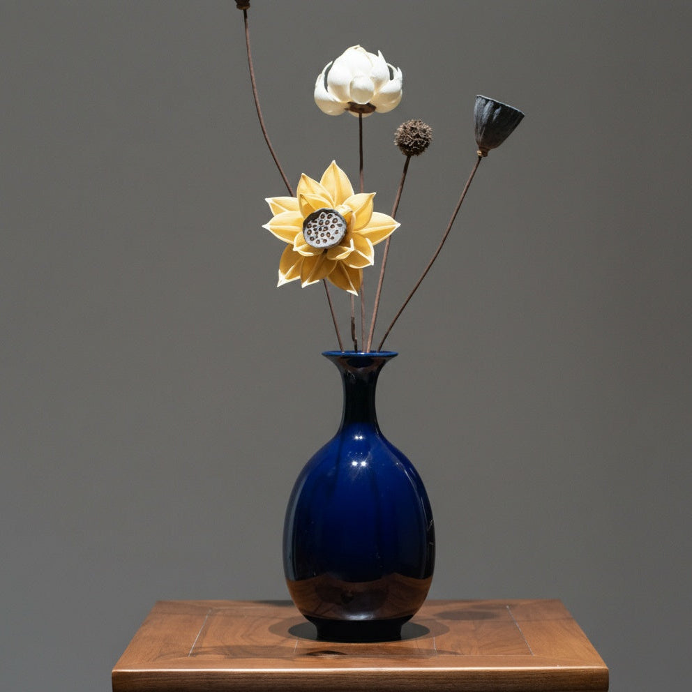Full view of navy blue ceramic pear vase with floral arrangement