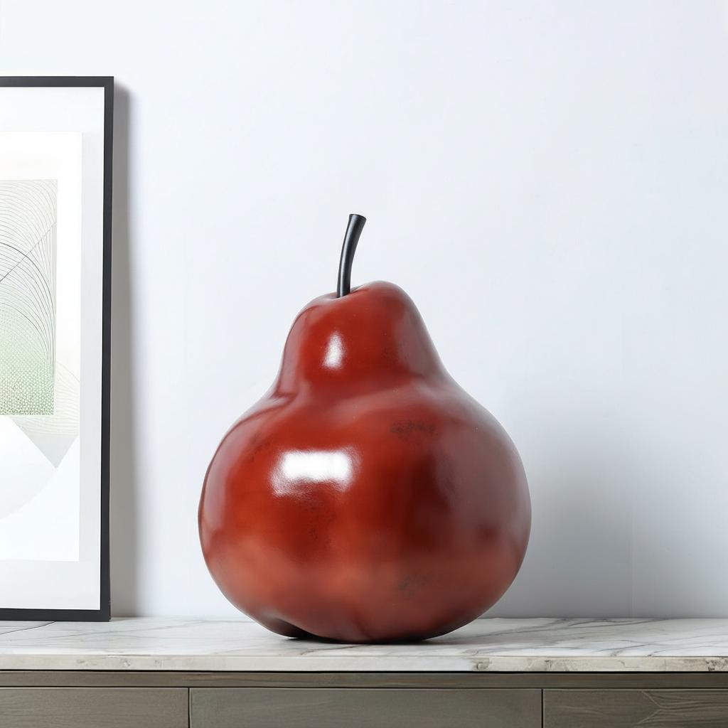 Angled view of glossy red pear statue showing curved silhouette