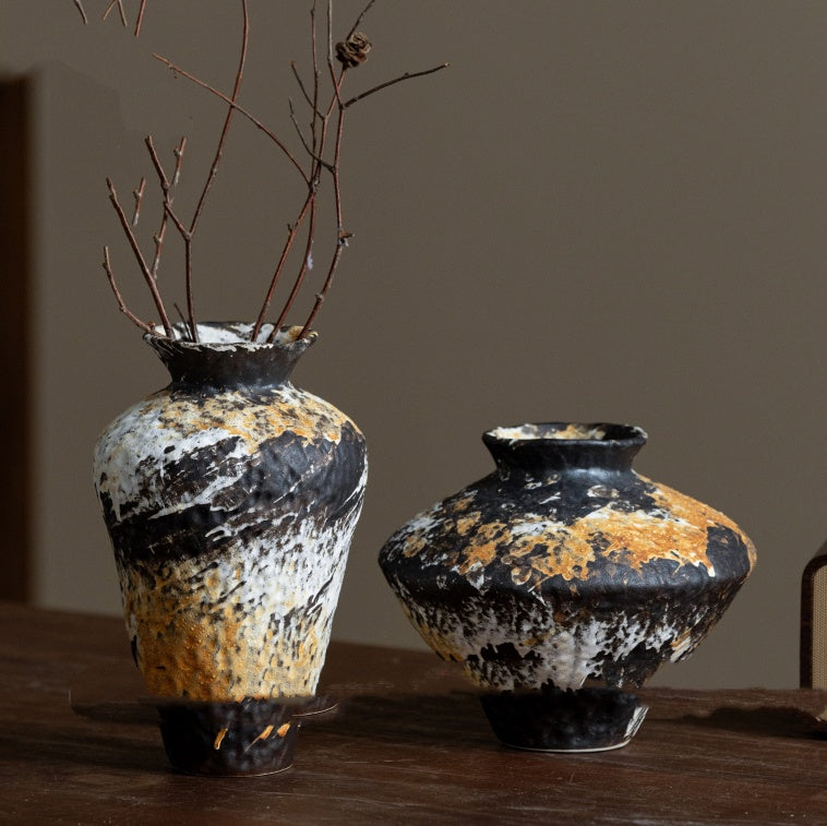 Two rustic ceramic vases with black white and ochre texture on wooden table