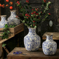 Distressed blue and white floral ceramic vases with red berries