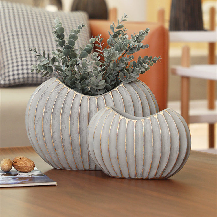 Distressed grey and gold ribbed ceramic vase set on table