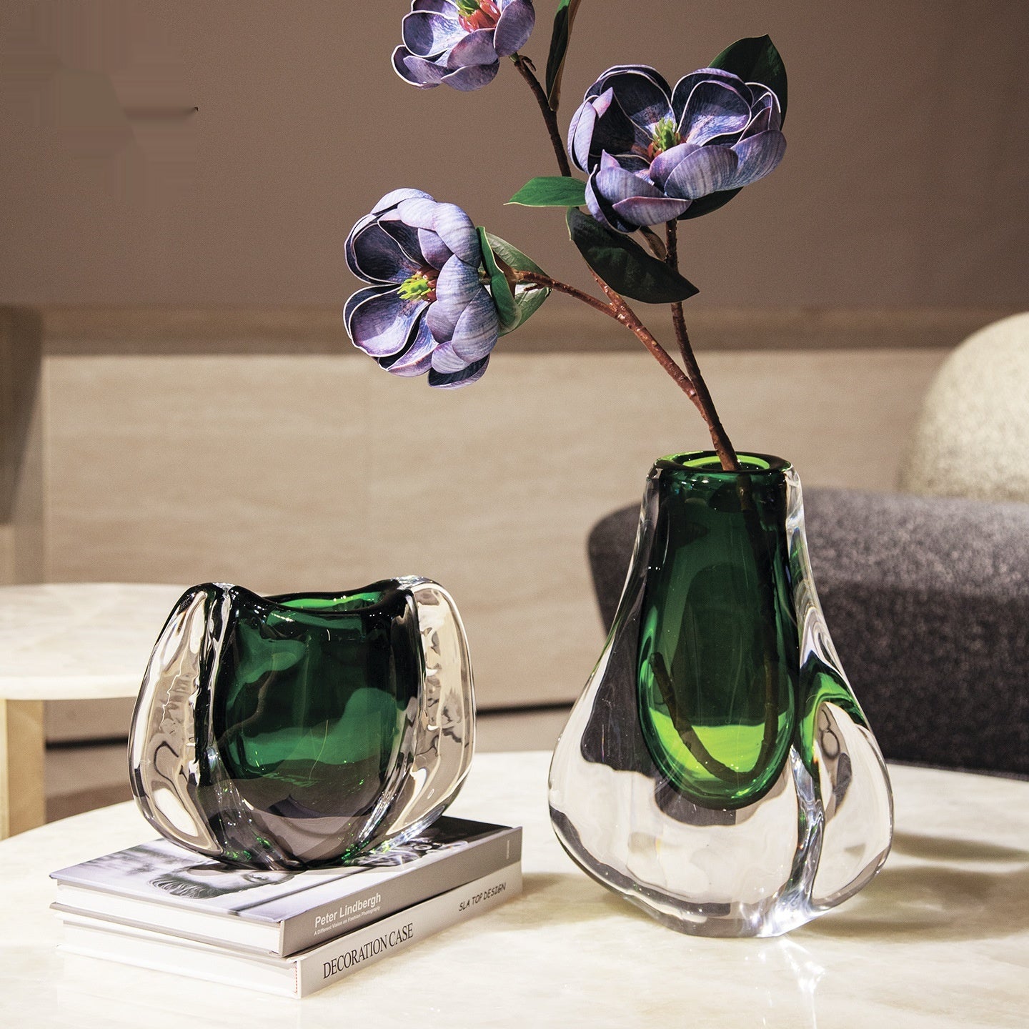 Emerald green and clear glass organic vase set on marble table