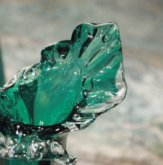 Close up detail of ruffled clear and green glass rim
