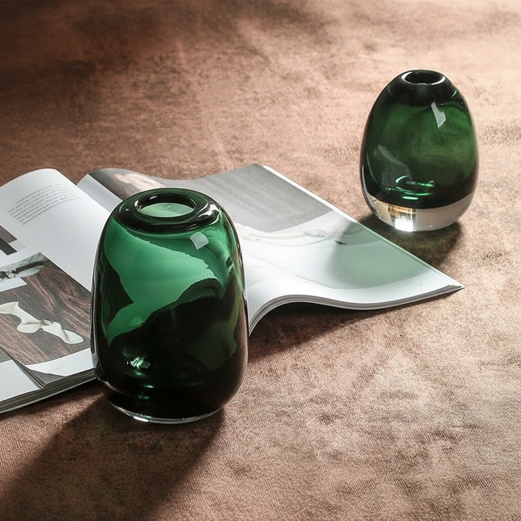 Two emerald green glass vases styled on table