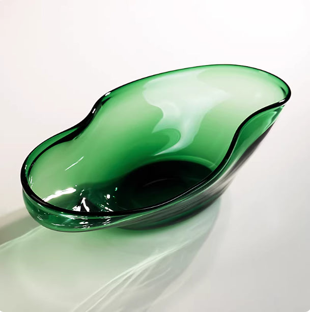 Angled view of empty emerald green glass bowl with light reflections