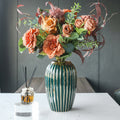 Luxury green and gold vase with floral arrangement on table
