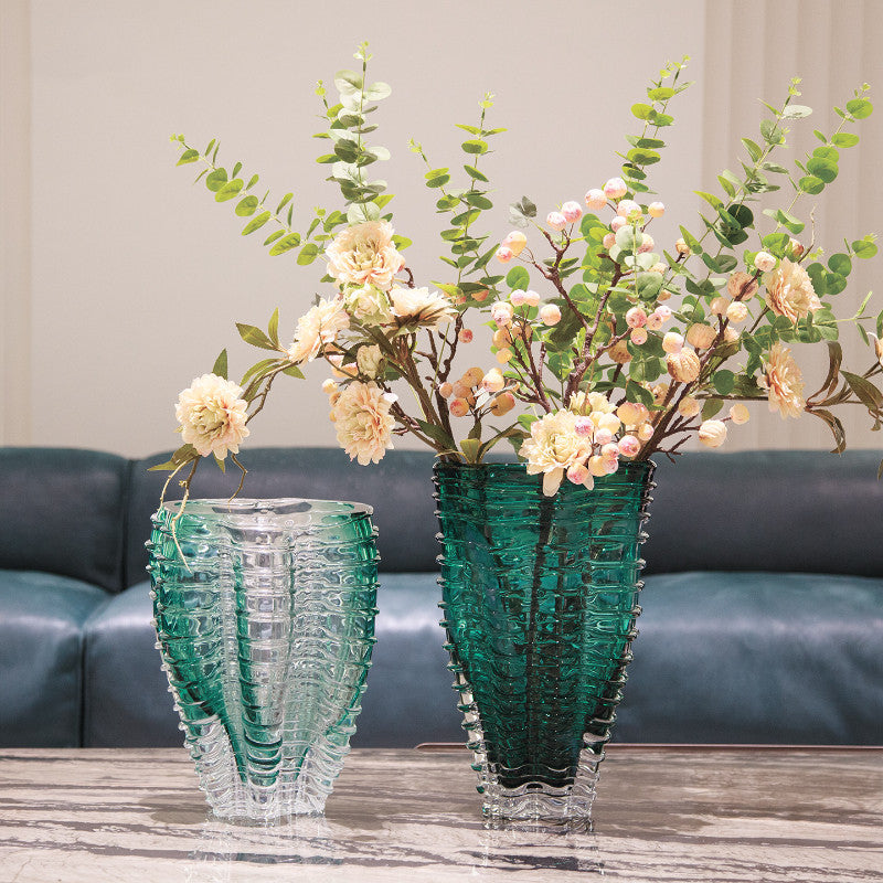 Emerald green and clear ribbed glass vases on marble table